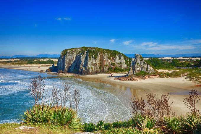 Praia da Guarita em Torres. Imagem composta por morros e praia.